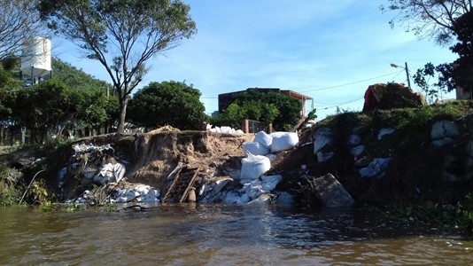 El avance del río sobre las casas del barrio hoy se intenta contrarrestar con bolsas de arena.